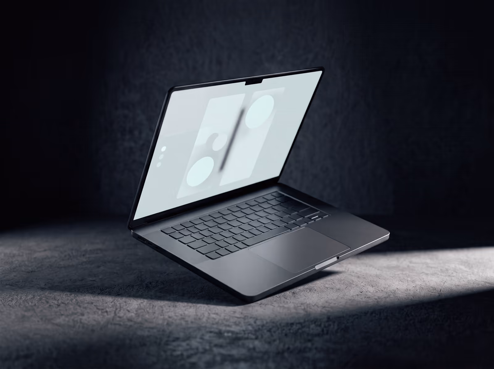An open laptop on a desk in a darkened room